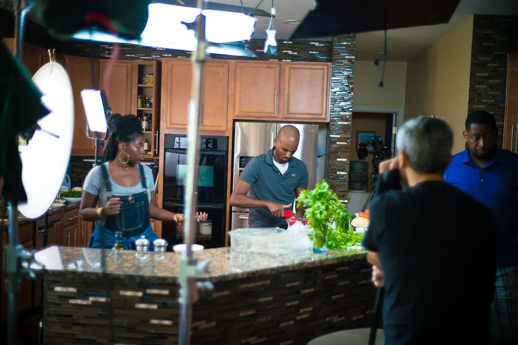 Nakia on set with a host and camera crew in a kitchen